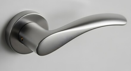 Fototapeta premium Close-up view of a sleek silver door handle attached to a white door, showcasing its modern design and smooth surface