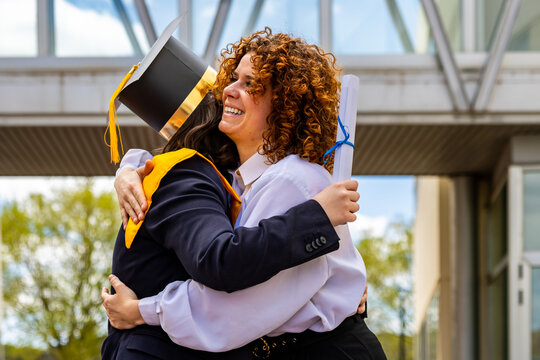 Two happy women hugging and celebrating graduation from university