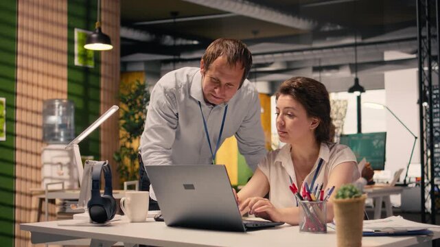 Business professionals collaborating on project planning and task management. Visual data, charts and graphs displayed on laptop in a corporate office workspace, forecasting insights.