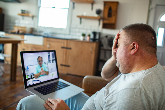 Ill man having telemedicine consultation at home