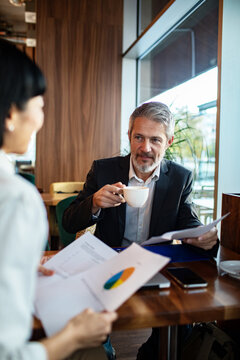Business colleagues discussing reports at cafe