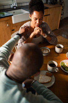 Couple sharing a comforting moment at home breakfast table
