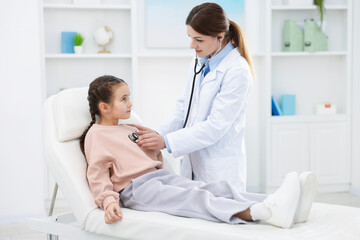 Obraz premium Doctor checking little girl with stethoscope in hospital