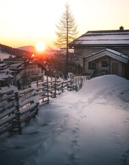 Fototapeta premium Winter Sunrise over Snow Covered Alpine Village in Falkert, Austria