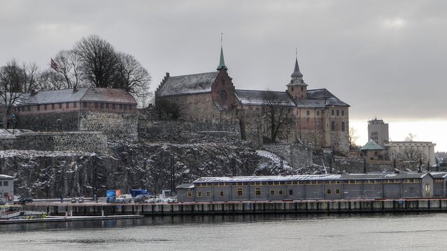 Winter view of fortress Akershus, also called Akershus Festning in norwegian language, photographed from banks of Oslofjord during winter season, february 2026. 