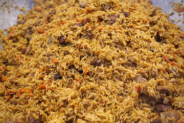 Pilaf with meat and spices in big pan