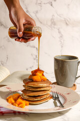 Pouring Syrup on Pancakes with Fresh Fruit &ndash; Breakfast Food Concept