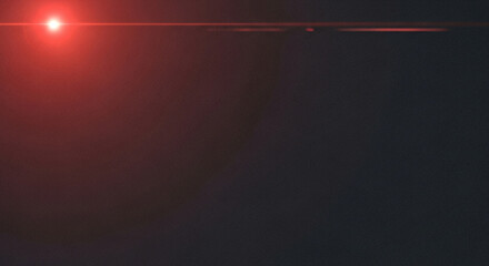 Bright Red Light Lens Flare on a Dark Textured Abstract Background