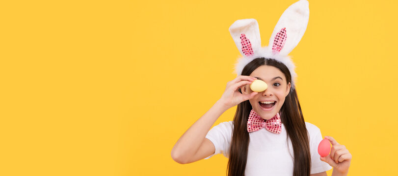 surprised easter teen girl in bunny ears and bow tie hold painted eggs. Easter child horizontal poster. Web banner header of bunny kid, copy space.