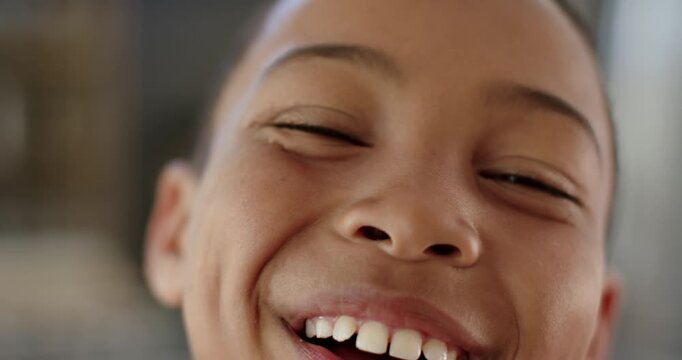 African American boy moving toward camera at home smiling, squinting and laughing, reacting to play