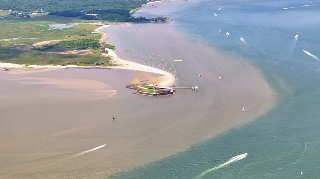Aerial view of Fort Sumter National Monument in Charleston, South Carolina with lowcountry landscapes with boats traveling in ocean water - 4K Drone