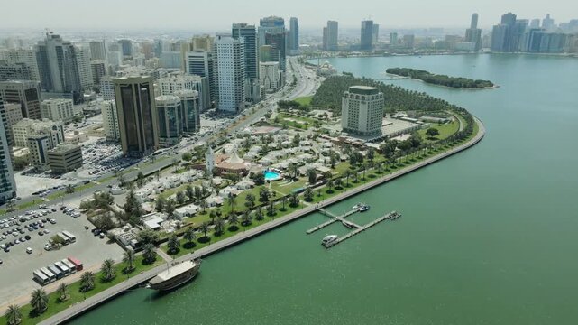 4K aerial drone view of Sharjah skyline and Khalid Lake with Al Noor Mosque and modern skyscrapers, cinematic waterfront cityscape in the United Arab Emirates &ndash; Captured February 2026.
