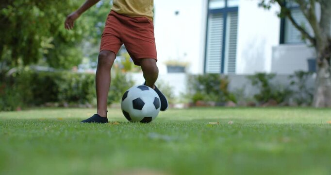 Teen is receiving soccer ball, juggling, trapping and dribbling on grassy lawn practicing control
