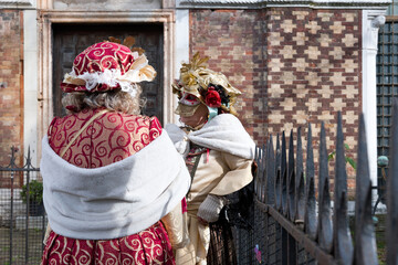 Venice, Italy - February 11, 2026 - People dressed in masks for the Venice Carnival have their...