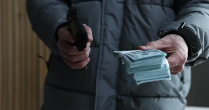 Woman giving money to dangerous criminal with gun indoors, closeup. Armed robbery