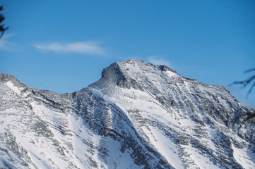 Sharp snow-covered mountain peaks against a clear blue sky