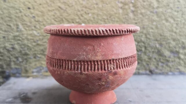 Matka Kulfi is served in a traditional terracotta pot. A small wooden spoon in the center. This rustic clay pot represents a simple, authentic treat. Ice cream served in a traditional style. 
