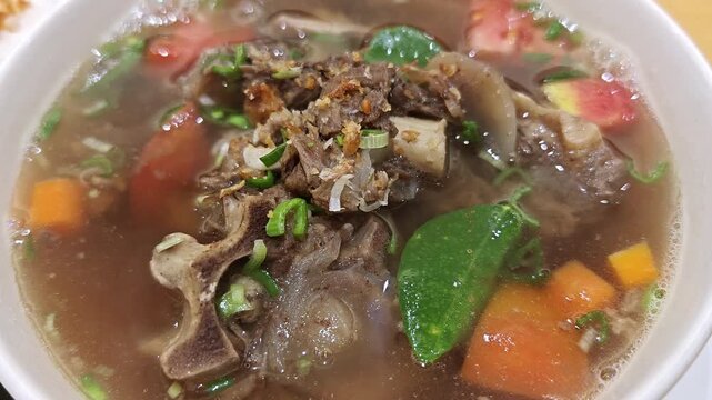 Close-up of Traditional Indonesian Sop Buntut Oxtail Soup with Vegetables and Rice