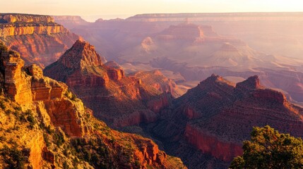 Majestic grand canyon at sunrise, showcasing layered red rock formations and vast vistas under a soft, hazy sky.