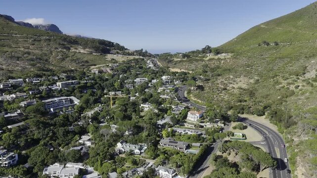 Drone lowers over neighborhood at base of Lion's Head in the late morning in Cape Town, South Africa