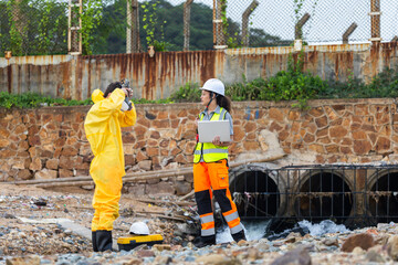Environmental technicians inspecting a drainage system and industrial waste water, Professional research team conducting field testing and pollution assessment at a factory waste water pipe
