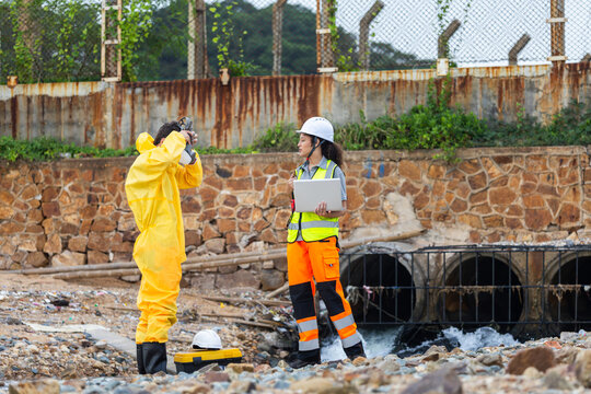 Environmental technicians inspecting a drainage system and industrial waste water, Professional research team conducting field testing and pollution assessment at a factory waste water pipe