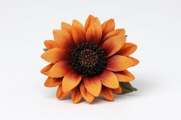 A vibrant orange artificial sunflower with a dark center and green leaves