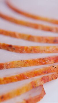 Turkey slices displayed. Thinly sliced orangespiced turkey fanned out. Detailed view of overlapping turkey pieces seasoned with spices and arranged in fan pattern