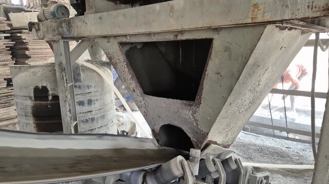 Professional RAW eye level close-up of a conveyor belt and hopper in a concrete block factory in Bangladesh, 4K UHD 30fps.
