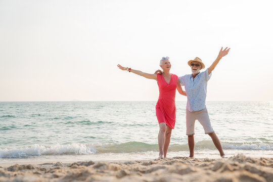 Happy senior couple using smart phone together on the beach