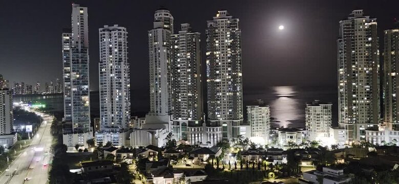 Panama City Skyline at Night with Full Moon Reflecting on Ocean