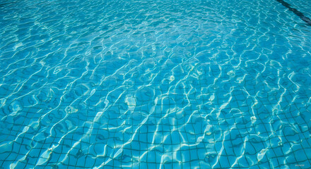Obraz premium The sun illuminates the rippling surface of clear blue water in a swimming pool.