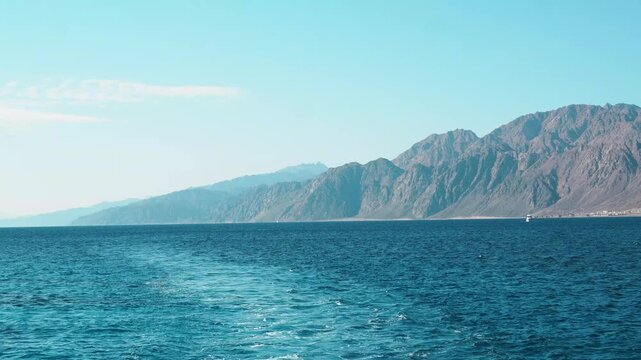Breathtaking summer landscape of the egyptian coast featuring a blue sea and horizon view from a mountain peak with clouds over the island bay on a red sea of the gulf of agaba dahab egypt