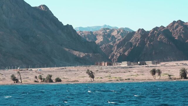 A scenic summer panorama of dahab features a clear blue ocean flowing toward the mountain coast under a bright sky, capturing a nature landscape on a red sea perfect for travel and tourism