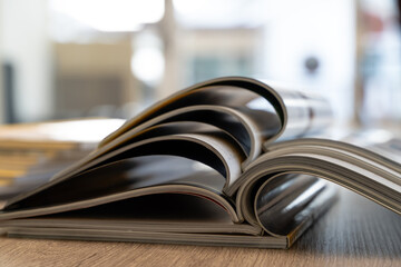 Education and research books and magazine pages stacked on desk, representing learning, reading, studying and publishing for editorial design.
