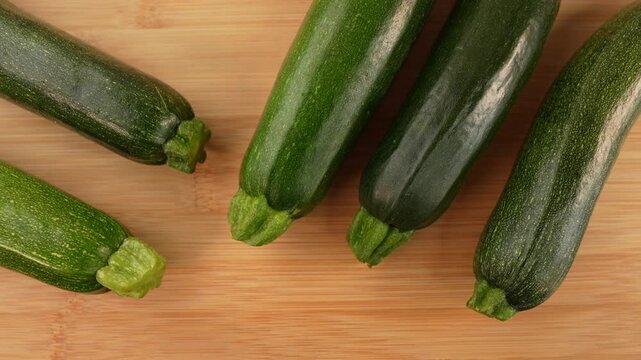 Fresh green zucchini on wooden background top view.