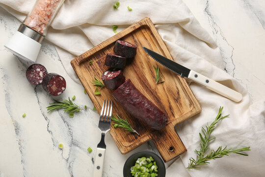 Composition with tasty blood sausage on white background