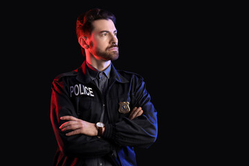 Male police officer with badge on black background