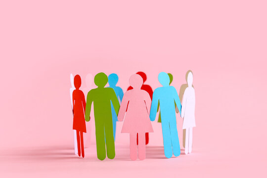 Paper human figures making circle on pink background. Diversity and inclusion concept