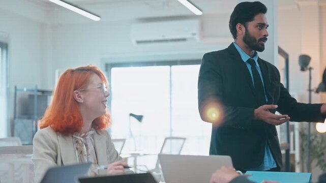 Multiethnic business and creative team collaborating meeting in modern office using AI assistant, big data, and digital tools for innovation and strategy.