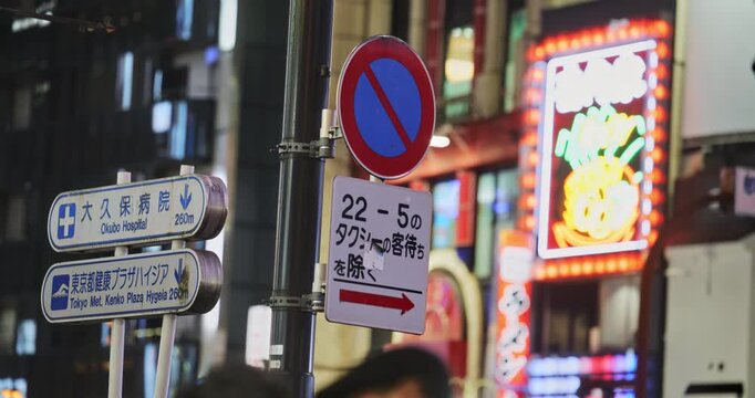 No entry sign in glowing lights of busy Japanese city - closeup