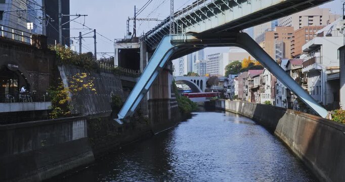 Quiet, rippling canal in Japanese city with overpass