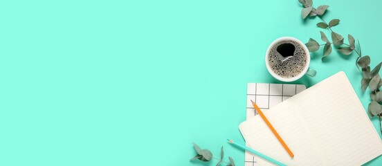 Cup of coffee, notebooks, pencils and eucalyptus branches on turquoise background with space for text, top view © Pixel-Shot