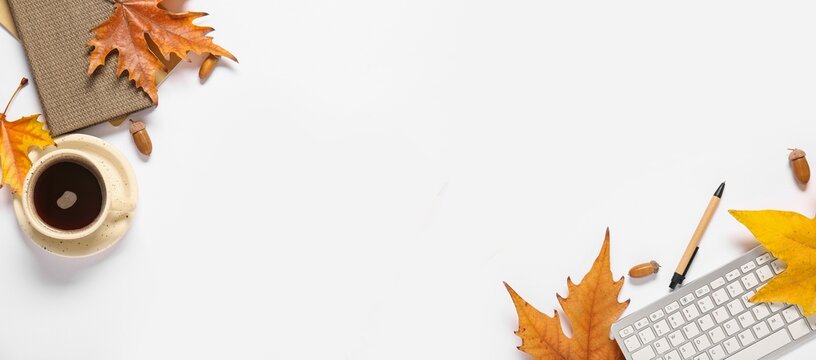 Cup of coffee, PC keyboard, notebooks, autumn leaves and acorns on white background with space for text, top view