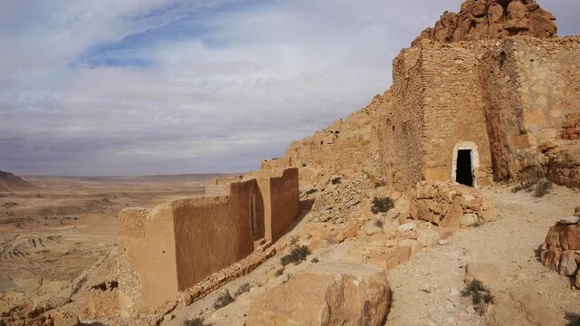 Panorama: Ancient Ksar Guermassa in southern Tunisia, featuring traditional Berber mudbrick granaries and arched storage rooms, showcasing Saharan architecture, history, and cultural heritage
