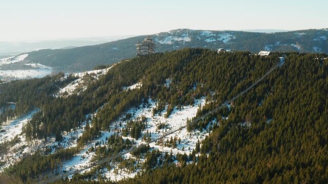 Aerial view of Sky Bridge 721 and Sky Walk observation tower rising above a forest landscape in winter