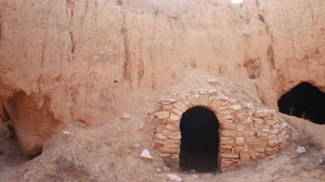 Panorama: Traditional troglodyte houses carved into rock in Matmata, Tunisia. Ancient underground dwellings in arid desert landscape, historic Berber architecture and cultural heritage site