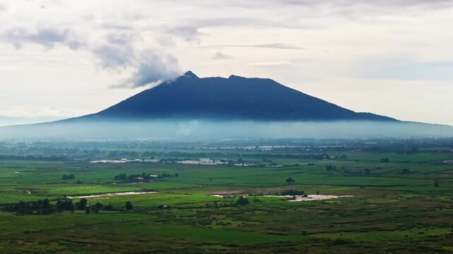 Telephoto drone beside Mount Arayat rising through haze, Pampanga Philippines
