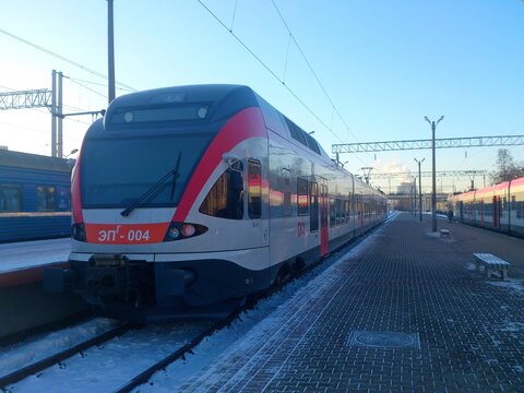 Modern Stadler FLIRT electric city train of Belarusian Railways at a snow-covered station platform on a sunny winter day, Minsk, 2014 