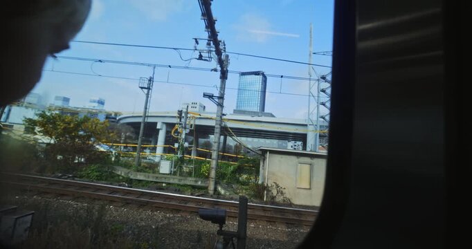 Silhouette of boy staring out train window in Japan - closeup